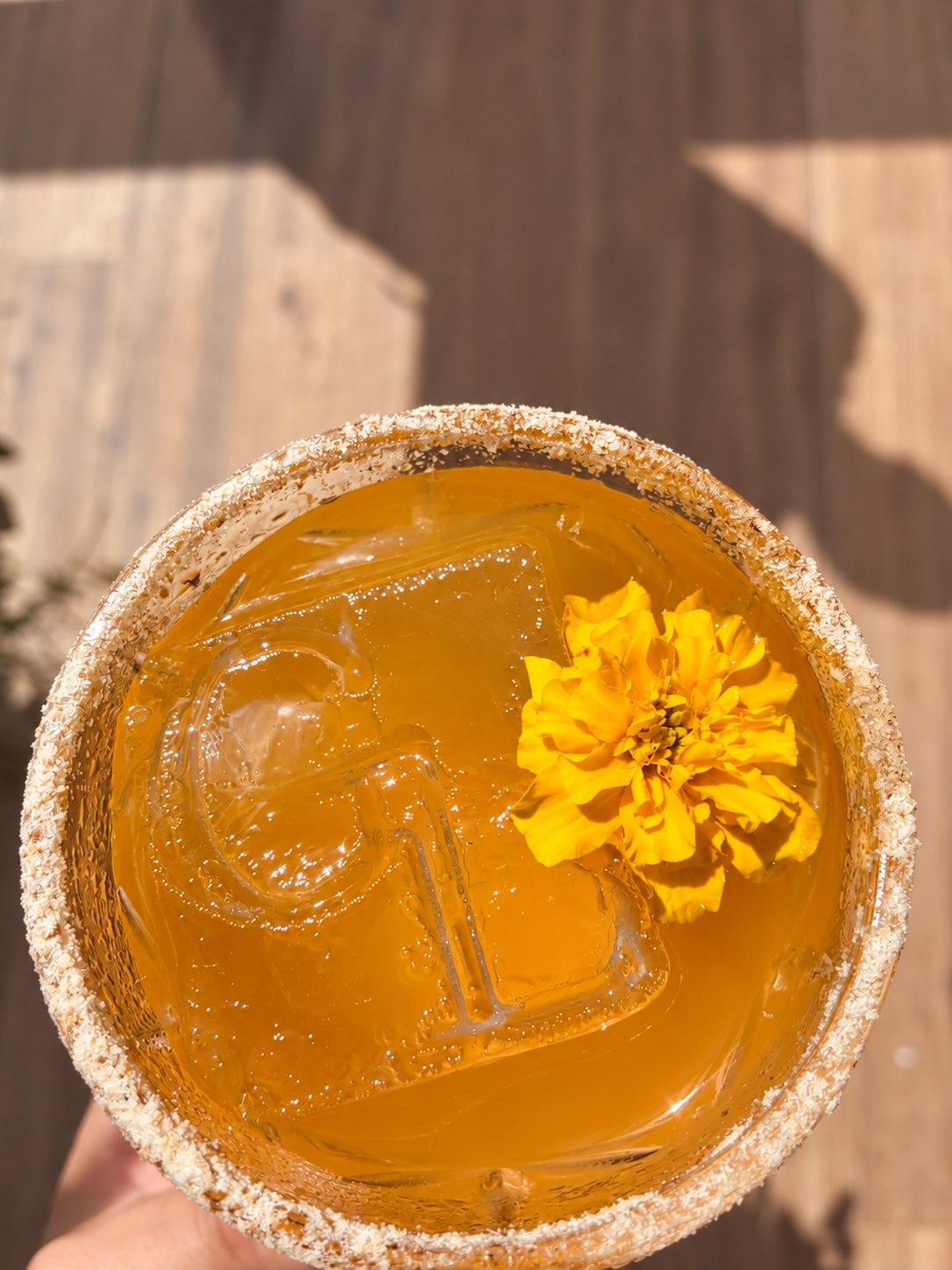 Coquetel dourado com gelo e flor amarela