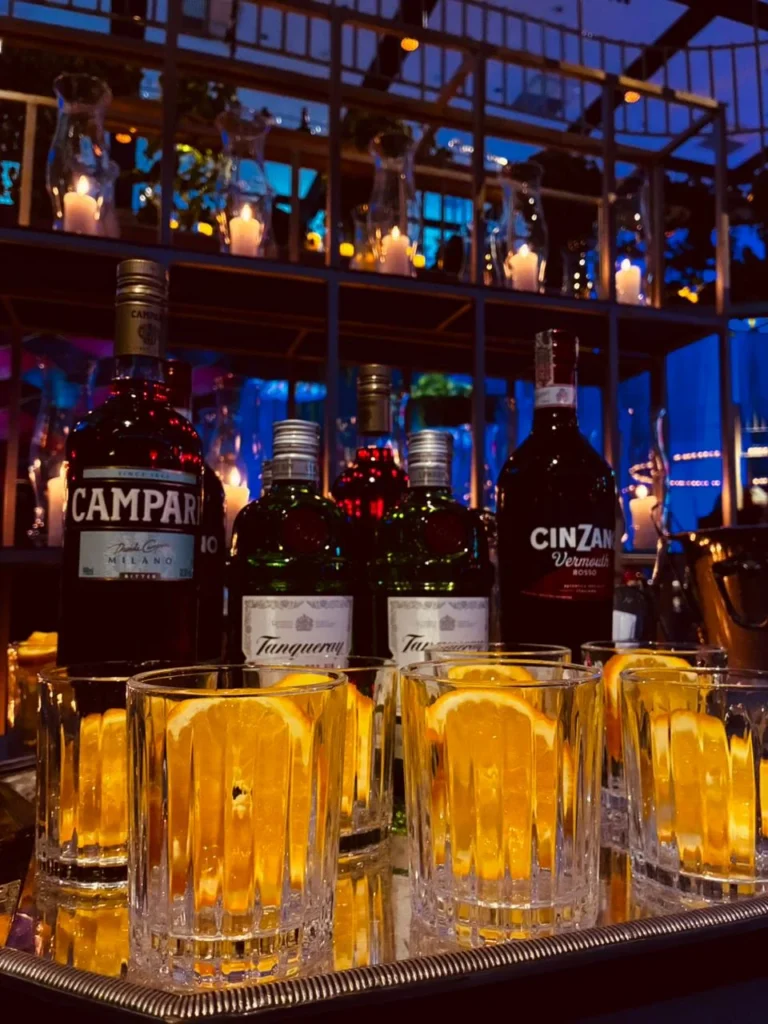 Detalhe de copos e bebidas sob iluminação noturna
